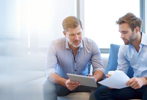 Mature,Businessman,Using,A,Digital,Tablet,To,Discuss,Information,With